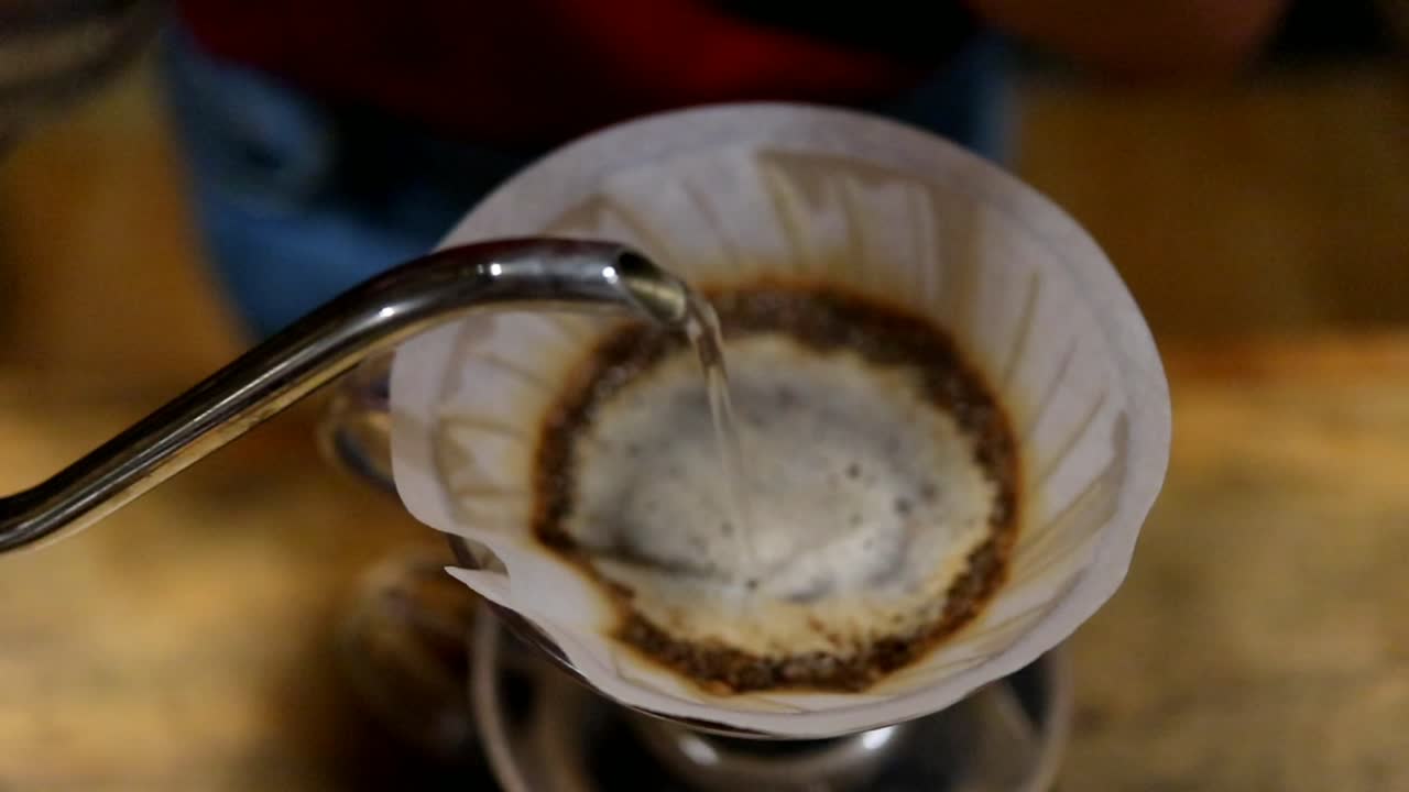 coffee brewing, step by step. Barista gently pours hot water on the surface of the ground coffee. Wetting the coffee