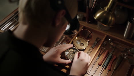 a watchmaker meticulously working on a pocket watch at a workbench