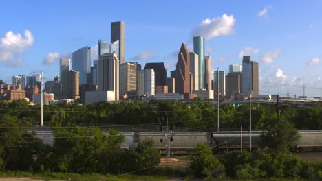 establishing shot of downtown houston, texas on cloudy but sunny day as train passes by