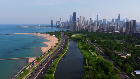 drone descends to reveal lincoln park south lagoon. chicago skyscrapers. summer
