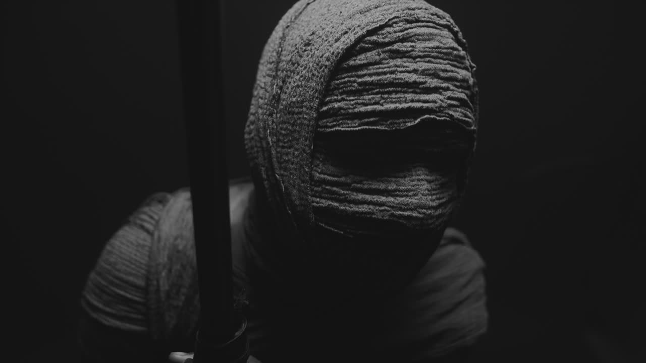 Una donna mummificata su uno sfondo scuro in posa con un bastone da passeggio.