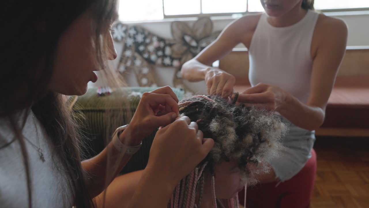 Two women braiding hair