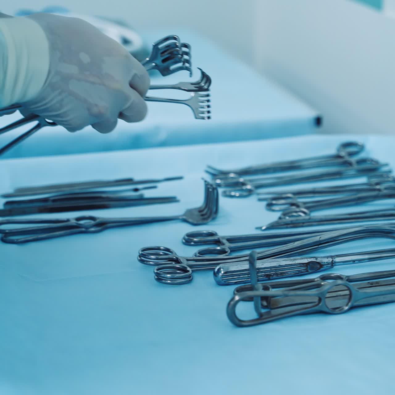Sterile medical tools on the table. Nurse in latex gloves laying out surgical instruments on the sterile table. Plastic surgery.