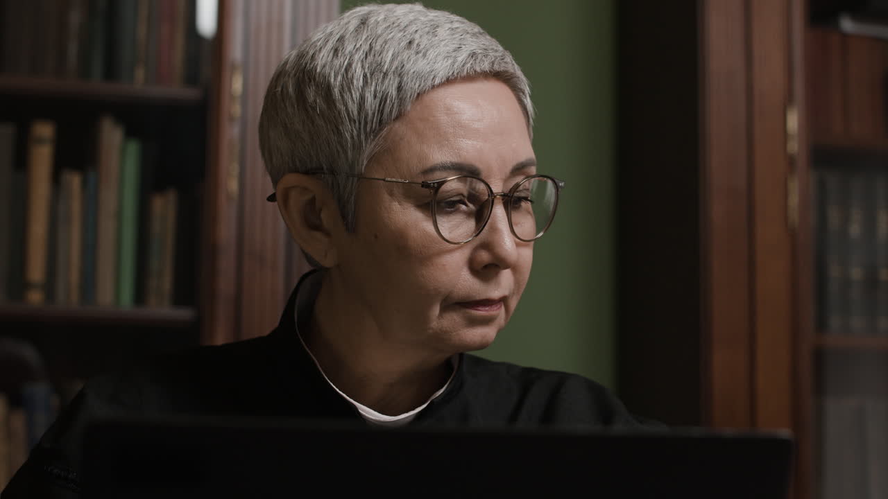 Senior Woman Working at a Laptop in a Library