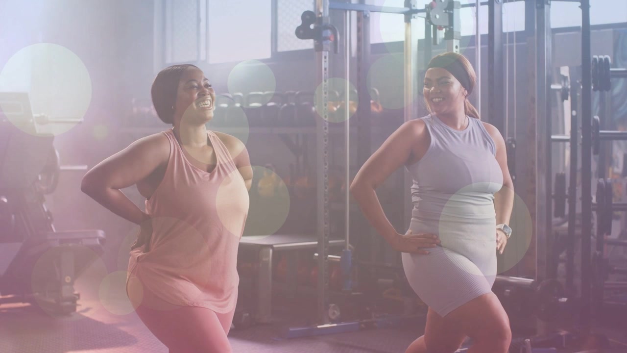 Due donne che eseguono affondi in uno studio fitness con un effetto lens flare, iniziando un affondo e finendo una serie