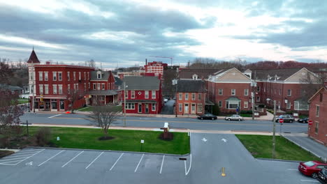 wide aerial rising reveal of traffic driving through old small town in east coast usa city, elizabethtown pennsylvania