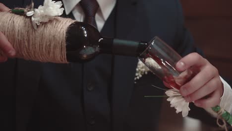 young man pours wine into a glass in a restaurant close-up slow motion