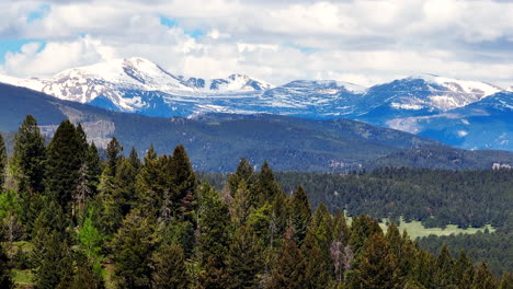 colorado cinematic aerial drone rocky mountains layers denver continental divide mount evans 14ers parallax zoom forest snow on peaks spring summer cloudy thunderstorm lush green evergreen aspen left