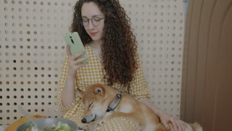woman with dog enjoying a meal in a cafe