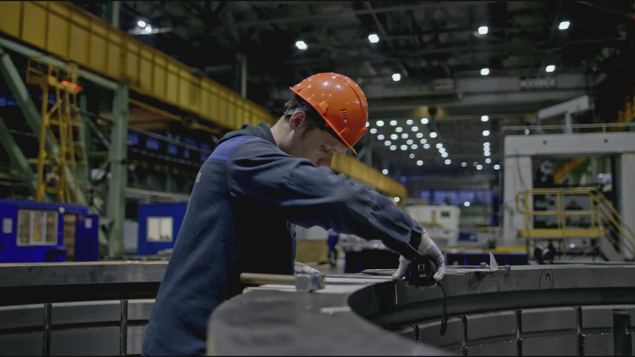 Factory Worker Inspecting Metal Part
