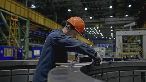 factory worker inspecting metal part