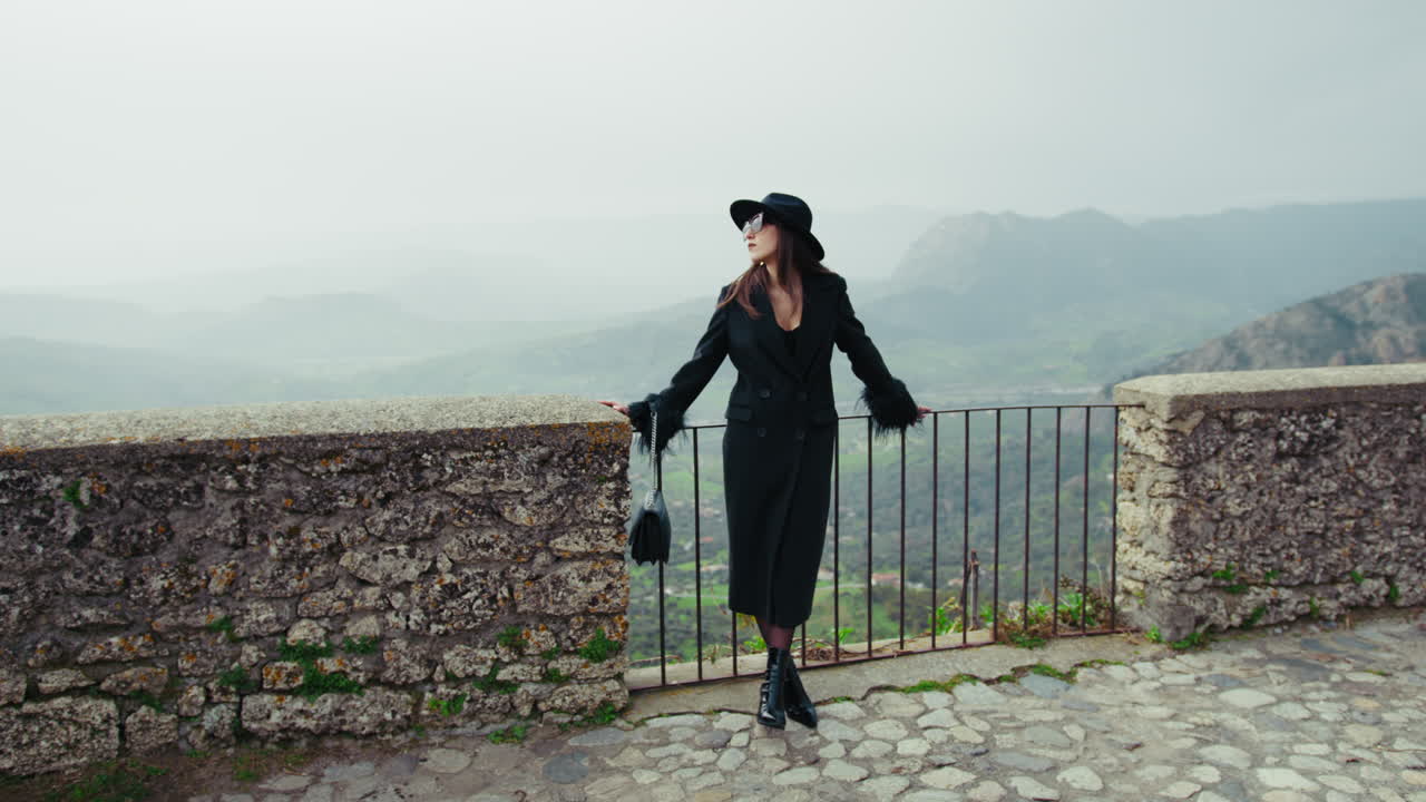 Elegant Model Posing On The Railing With A Mountain Landscape Background