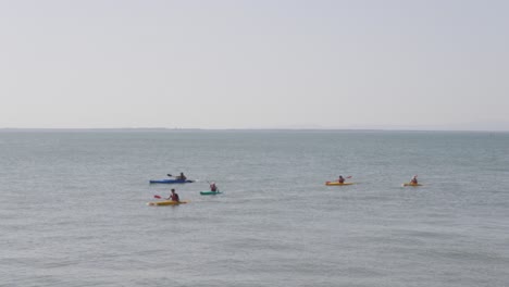 a group of people kayaking in tejo river in lisbon near vasco da gama bridge