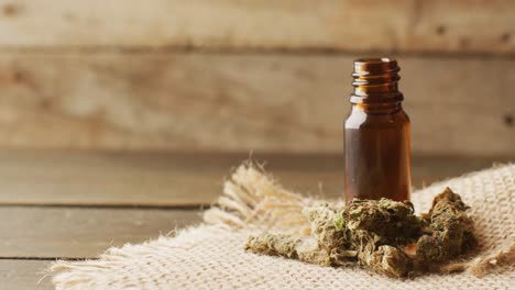 Video-of-marijuana-buds-and-bottle-of-cbd-extract-on-wooden-background