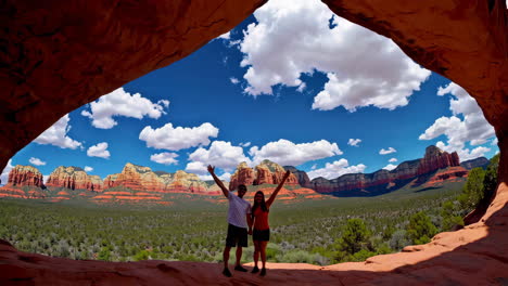 couple posing in a scenic red rock archway