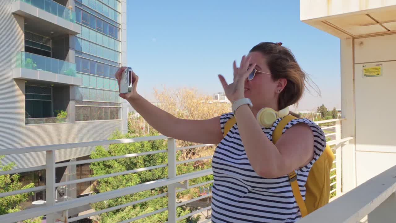 Una donna sta scattando una foto a un edificio con uno smartphone.