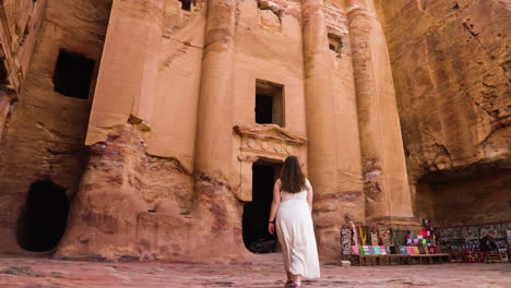 female traveler walking towards the treasury in the ancient city of petra in jordan