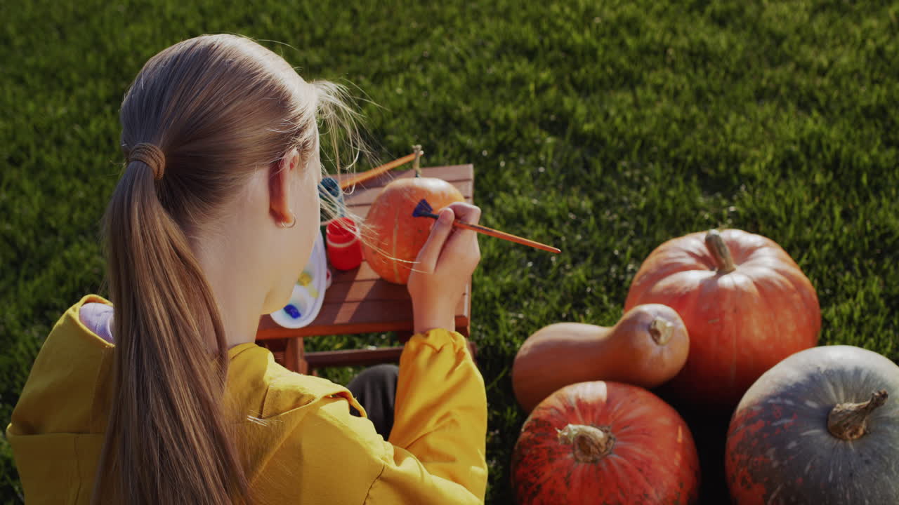 뒷면: 한 아이 가 호박 을 칠 하고, 할로윈 을 위한 장식 을 준비 하고 있다. 집 뒷마당 의 잔디 ⁇  에 앉아 있다