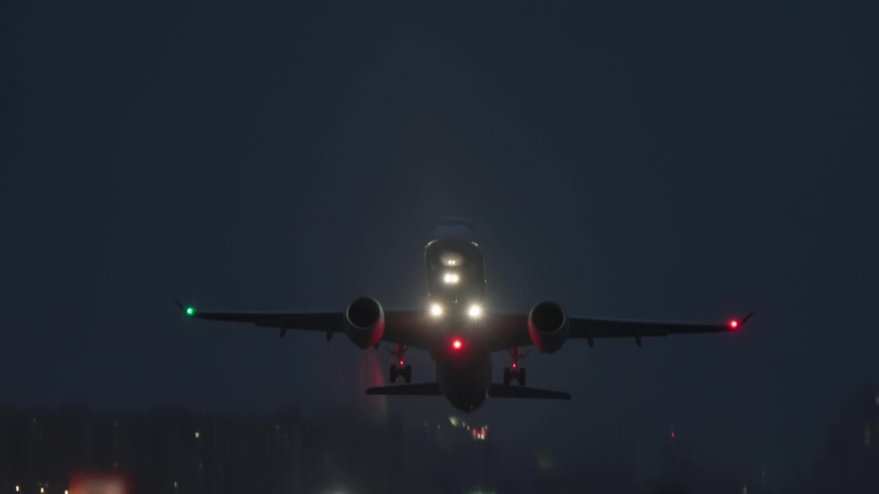 Aereo di linea che decolla dalla pista dell'aeroporto di notte.