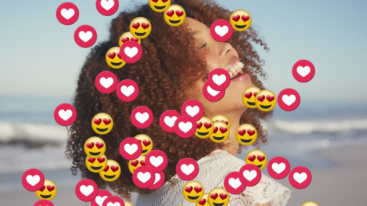 animación de corazones y emojis de amor sobre feliz mujer afroamericana en la playa soleada