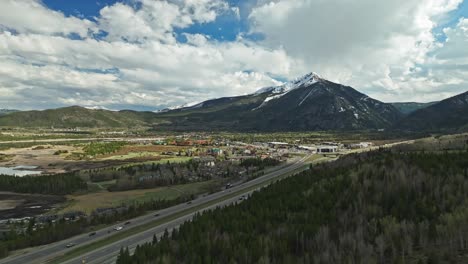 Drone-ascends-evergreen-forest-above-highway-leading-to-Frisco-Colorado