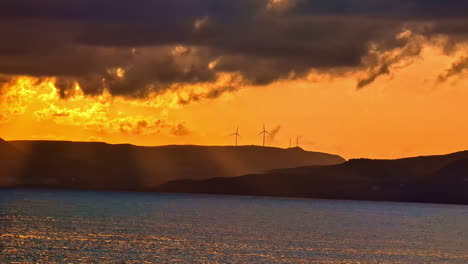 turbina eólica electricidad renovable puesta de sol vista del cielo dorado en el mar reflejo del sol