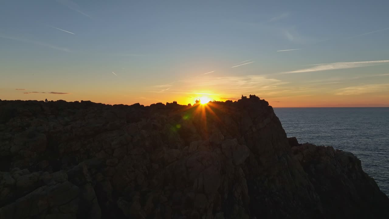 imágenes aéreas cinematográficas de la puesta de sol sobre acantilados rocosos y empinados en menorca, españa