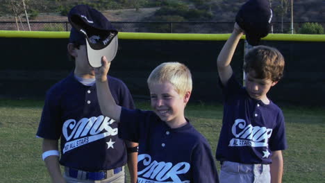 youth baseball players pound their chests and gesture to the sky