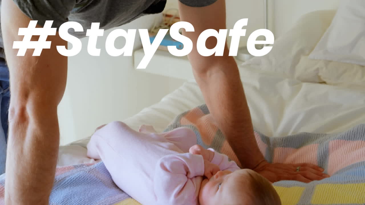 Animation of stay safe text over father and child at home