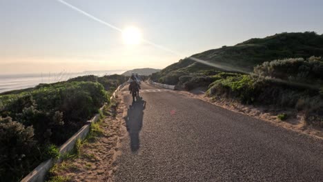 cyclist riding along coastal path at sunrise