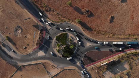 Von-Oben-Nach-Unten-Drohnenansicht-Eines-Belebten-Kreisverkehrs-In-Portugiesischen,-Orangefarbenen-Und-Grünen-Erdtönen