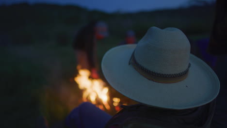 grupo disfrutando del fuego de la fogata al anochecer en cámara lenta
