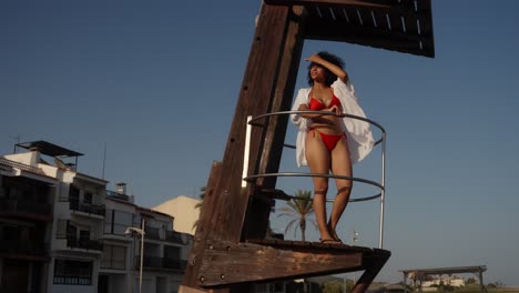 Woman in bikini on lifeguard tower