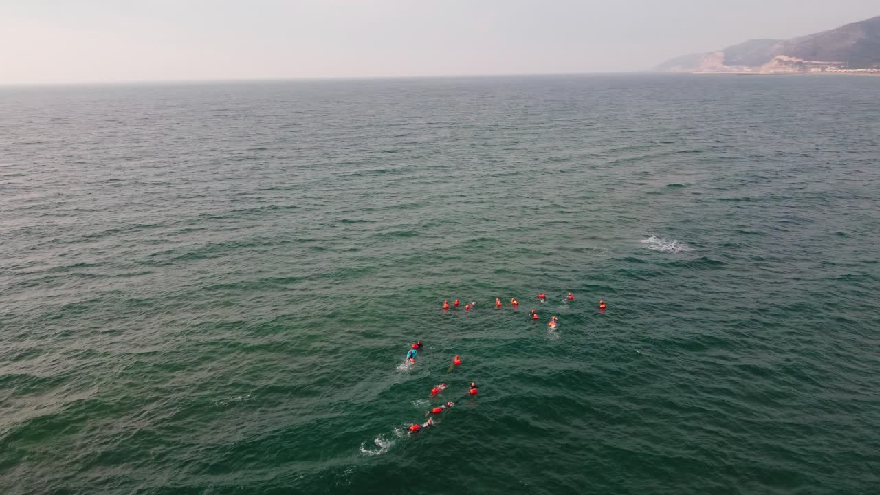 grupo de nadadores en formación en la playa de castelldefels, barcelona, mar tranquilo, vista aérea