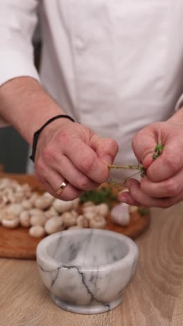 chef preparing thyme for mushrooms dish