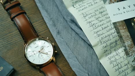 top view of a work desk with one fossil watch and old letters