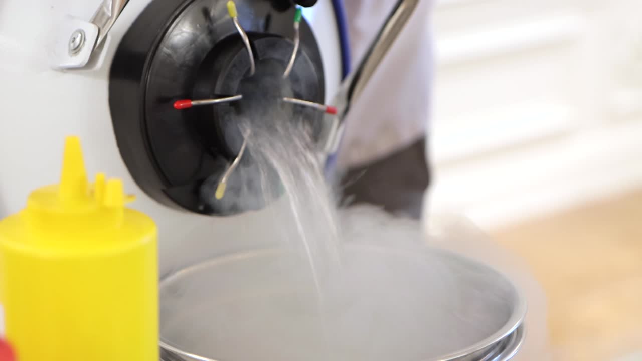 한 남자 가 특수 한 병 에서 강철 그 에 액체 질소 를 고 있다