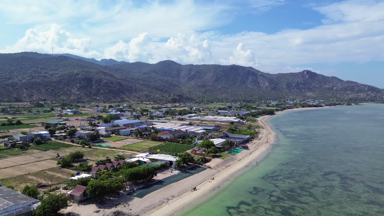 Elevated aerial zoom out exposing the vast turquoise expanse and coastal layout of My Hoa Lagoon in Phan Rang, Vietnam.