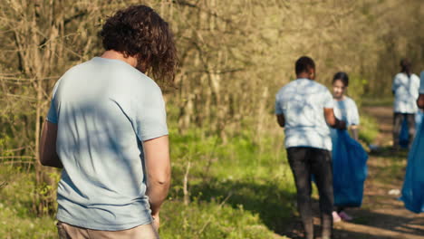 equipo de voluntarios limpiando el área forestal de basura y plástico