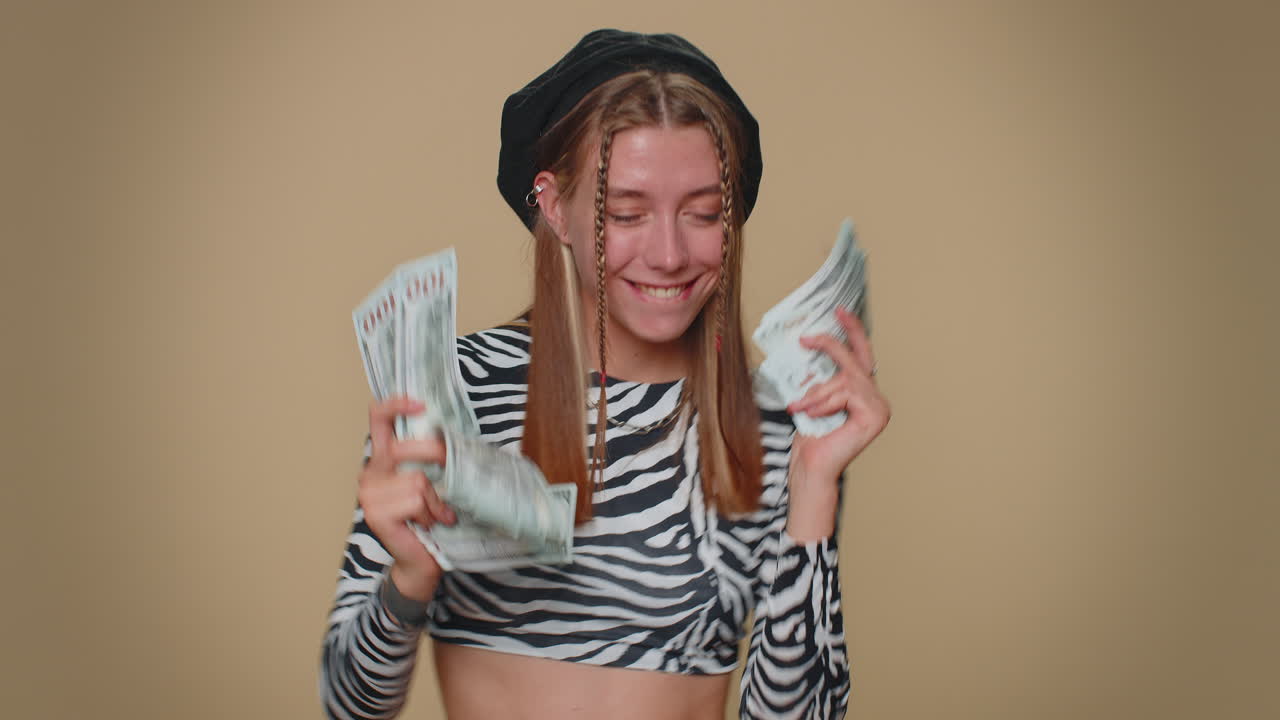 Vrouw houdt waaier van geld, dollarbiljetten, viert dans, succesvolle zakelijke carrière, loterijwinnaar