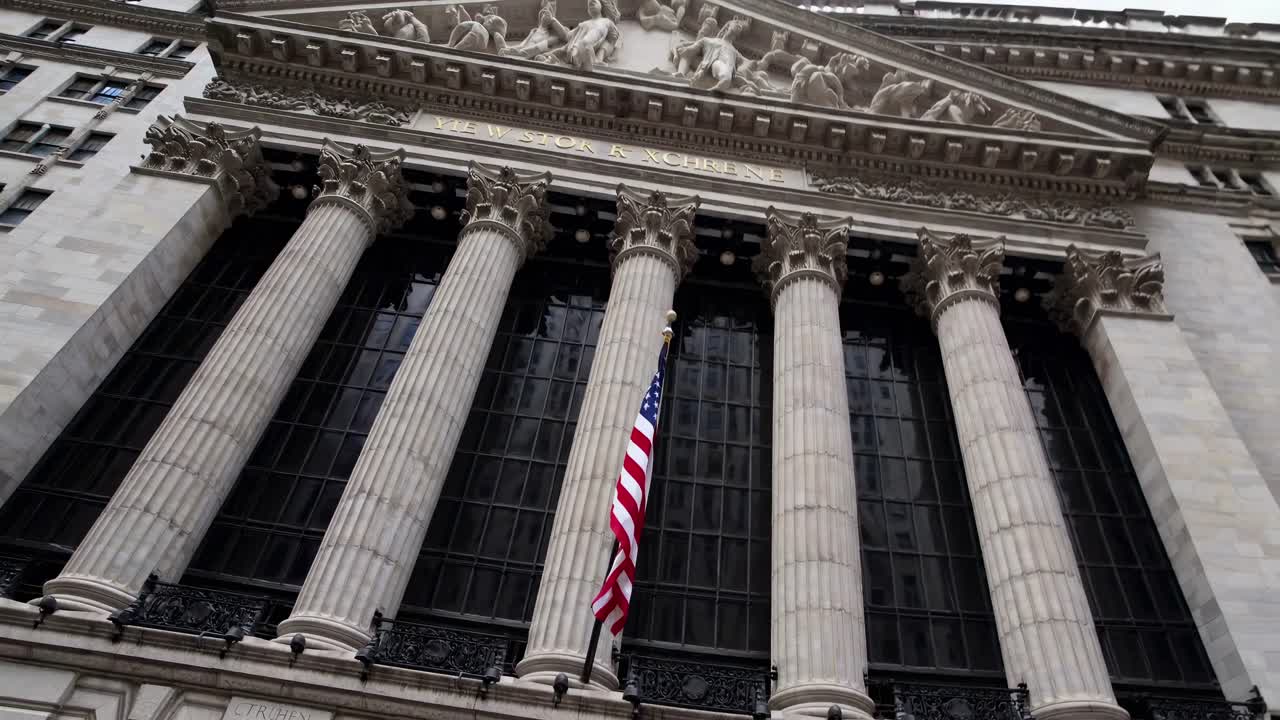 Low-angle video shot of a historic building's grand facade with tall columns and an American flag