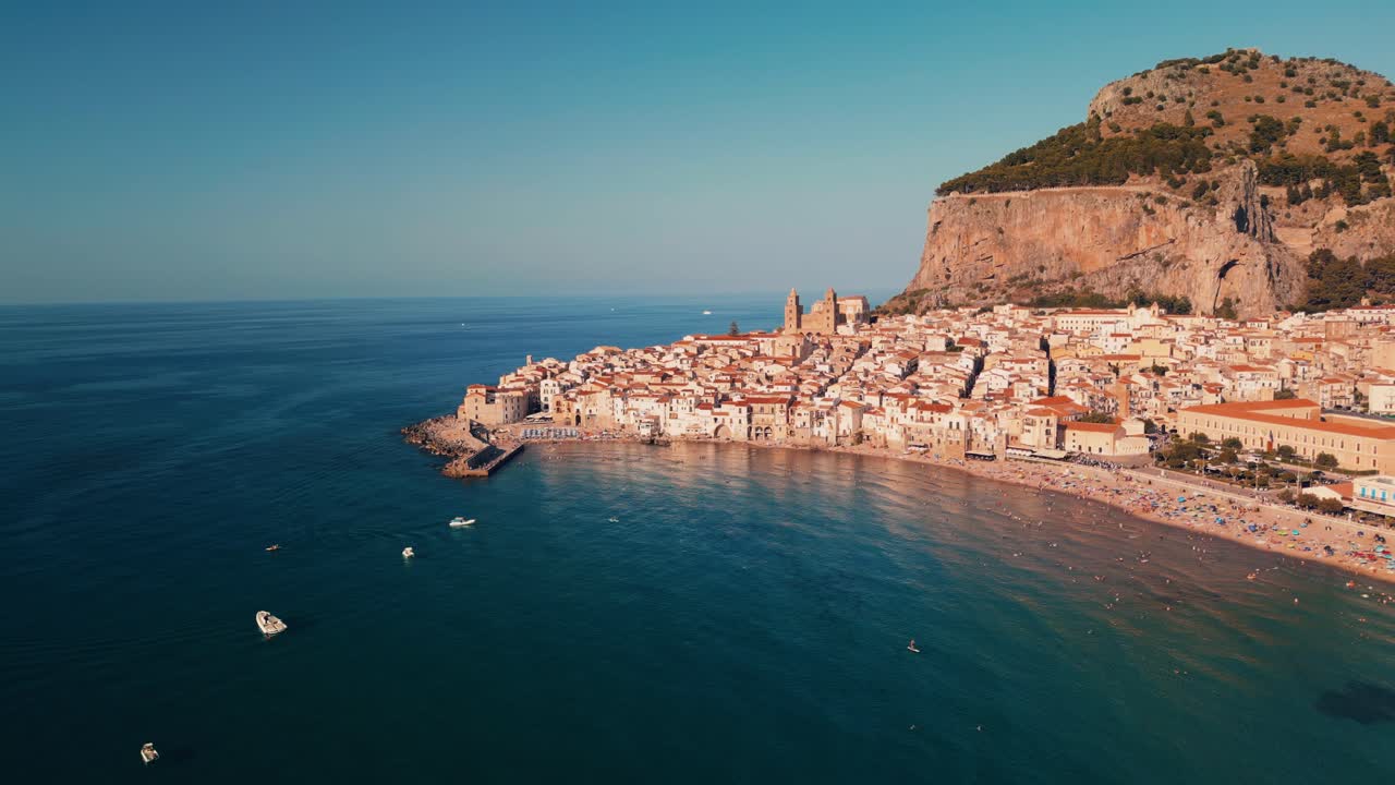 Filmato aereo grandangolare di Cefalù che mostra l'intera costa, l'attività balneare e le scogliere circostanti