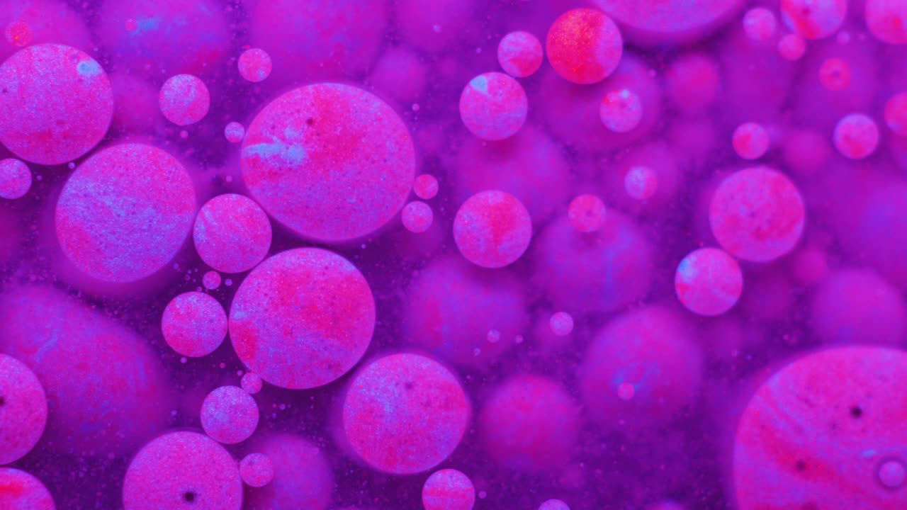 Slow Motion Bright Neon Color Bubbles Oil Beautiful Fluorescent Paint Sparkling Color Moving Multicolor Close up. Acrylic Neon Paint. Fantastic Surface. Abstract Colorful Transformation Gravitation.