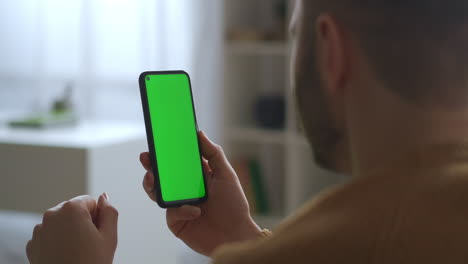 Video-Chat-En-Un-Teléfono-Inteligente-Con-Pantalla-Verde-El-Hombre-Está-Escuchando-Y-Asintiendo-Con-La-Cabeza-Vista-De-Cerca-A-Través-De-La-Tecnología-Del-Hombro-Para-La-Comunicación-A-Distancia