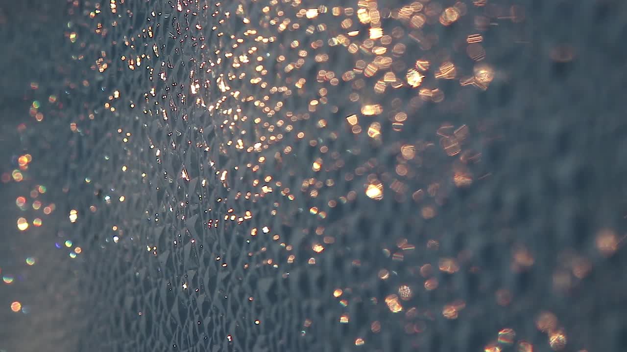 여름 일출 동안 거친 표면에 빛나는 황금빛 보케를 닫습니다