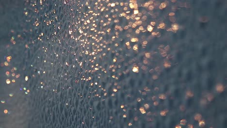 close up of golden bokeh glowing on a rough surface during a summer sunrise