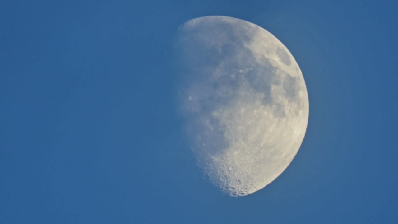 검은 하늘을 배경으로 느리게 움직이는 달