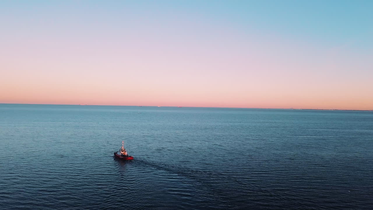 drone volando sobre el barco de pesca navegando en el mar al atardecer