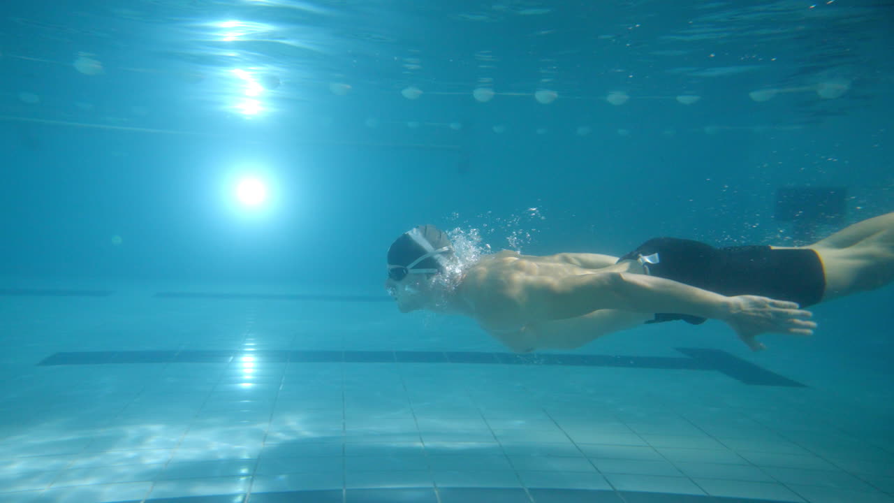 Uomo che nuota sott'acqua in una piscina