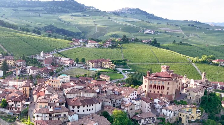 Riprese aeree con drone che rivelano il villaggio di Barolo e il castello storico tra le dolci colline vitate italiane